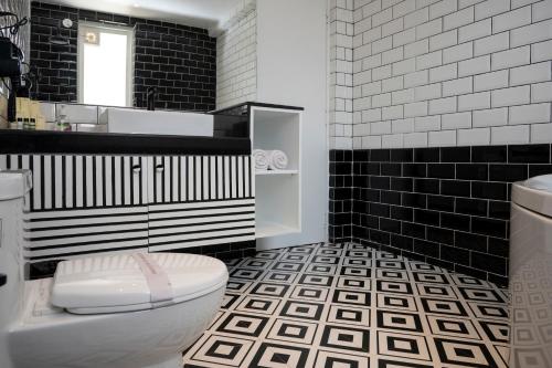 - une salle de bains en noir et blanc pourvue de toilettes et d'un lavabo dans l'établissement Richmonde Ananta Elite Luxurious Villa & Apartments,Goa, à Baga