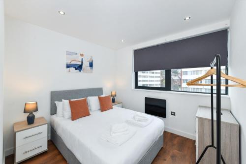 ein Schlafzimmer mit einem weißen Bett und einem Fenster in der Unterkunft Carlton Heights - A beautiful, inviting and modern 2 bedroom apartment, perfect for corporate stays and leisure in Nottingham