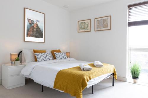 a bedroom with a bed with a yellow blanket on it at Spacious 2 Bed Apartment in Central Location in London