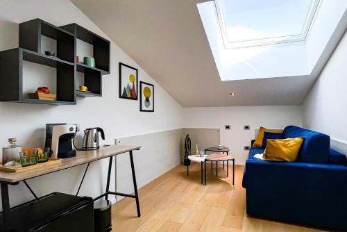 Alfea Deluxe Loft & Rooms في ترينتو: غرفة معيشة مع أريكة زرقاء ومكتب