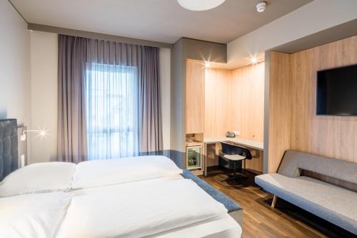 a hotel room with a bed and a tv at Hotel Cult Frankfurt City in Frankfurt/Main