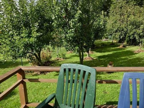 two green lawn chairs sitting next to a wooden fence at Ferienhäuschen Hochufer in Lohme
