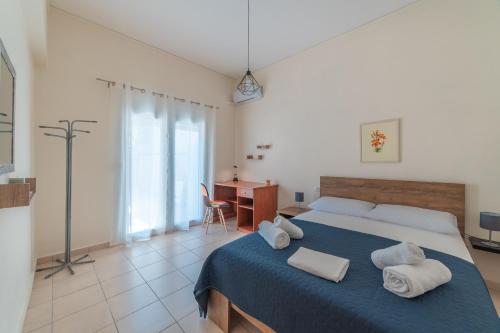 a bedroom with a bed with towels on it at Stylish Central Renovated Apartment in Heraklio Town