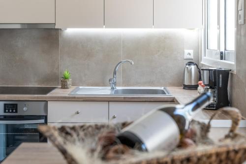 a kitchen with a sink and a bottle of wine at Stylish Central Renovated Apartment in Heraklio Town