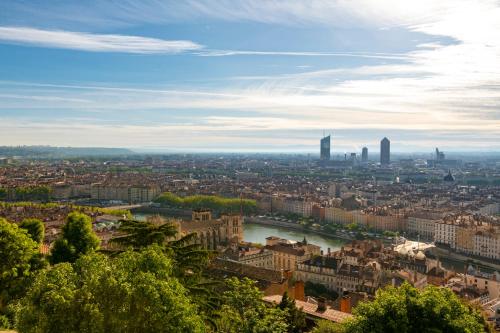 - une vue sur une ville avec une rivière et des bâtiments dans l'établissement Villa Maïa, à Lyon