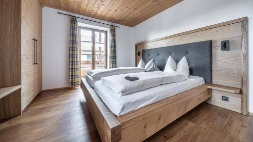a bedroom with a large bed with a wooden headboard at Ferienwohnungen am Lahnerbach in Lenggries