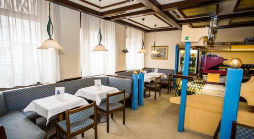 ウィーンにあるホテル ハドリガンのテーブルと椅子が備わるレストラン