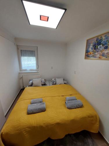 un grande letto giallo in una stanza con lucernario di Relax apartman a Cserszegtomaj