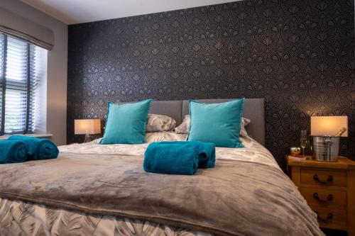 ein Schlafzimmer mit einem großen Bett mit blauen Kissen in der Unterkunft Number 24 in Lymington