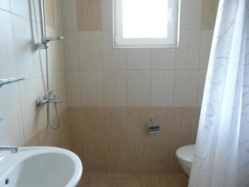 baño con lavabo y aseo y ventana en Семеен Хотел Детелини en Primorsko