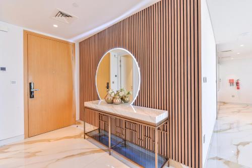 a bathroom with a round mirror and a sink at Lavish & Equipped oceanfront 2 BR facing Ain Dubai in Dubai