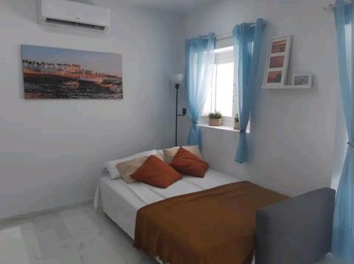 a small bedroom with a bed and a window at Casa Playa Caleta, a 4 minutos de la playa in Cádiz