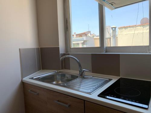 a kitchen with a sink and a window at Studio 28 3ου ορόφου στο Χαλάνδρι in Athens