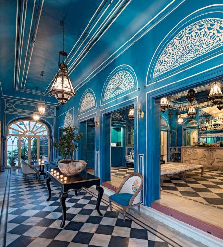 a room with blue walls and a table and chairs at Hotel Narain Niwas Palace in Jaipur