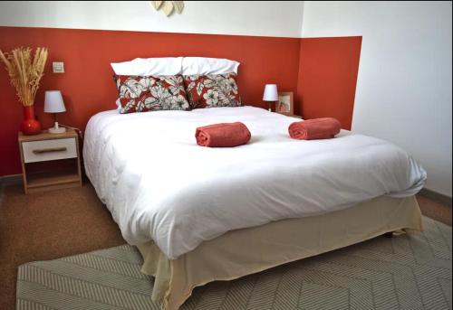 ein Schlafzimmer mit einem großen weißen Bett mit roten Wänden in der Unterkunft Joli duplex ensoleillé in Capbreton