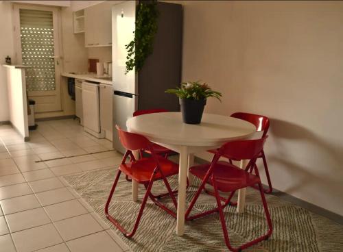 eine Küche mit einem weißen Tisch und roten Stühlen in der Unterkunft Joli duplex ensoleillé in Capbreton