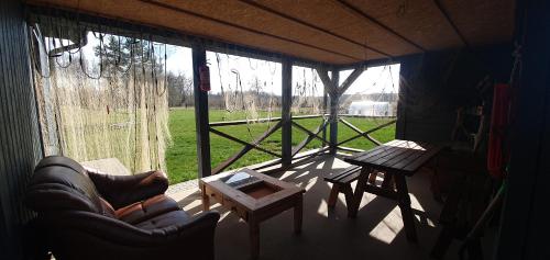 eine abgeschirmte Veranda mit einem Sofa und einem Tisch in der Unterkunft ApartmentApsuciems in Apšuciems