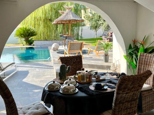 ein Tisch mit Essen und Tee neben einem Pool in der Unterkunft Les Lofts de Bouzigues - Jacuzzi privé - Plage 350m in Bouzigues