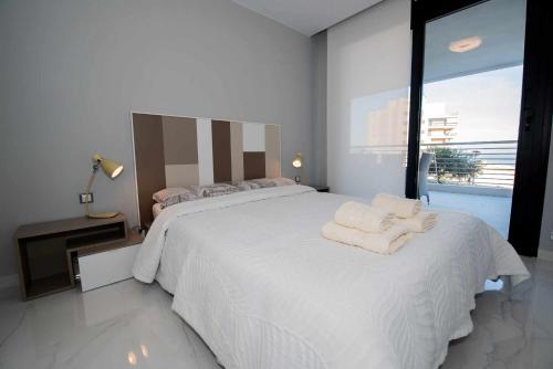 アレナレス・デル・ソルにあるApartamento INFINITY View SPAIN Holidayのベッドルーム1室(大きな白いベッド1台、タオル付)