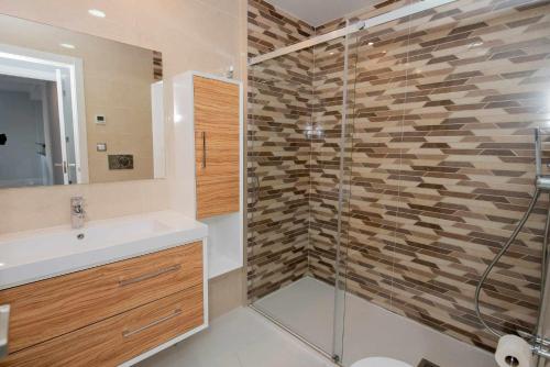 アレナレス・デル・ソルにあるApartamento INFINITY View SPAIN Holidayのバスルーム(洗面台、ガラス張りのシャワー付)