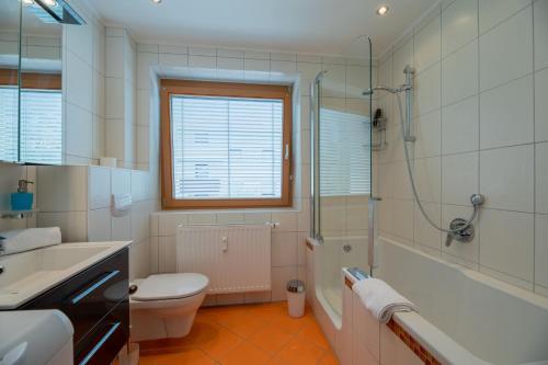a bathroom with a toilet and a sink and a shower at enJoy Appartements in Sankt Kanzian