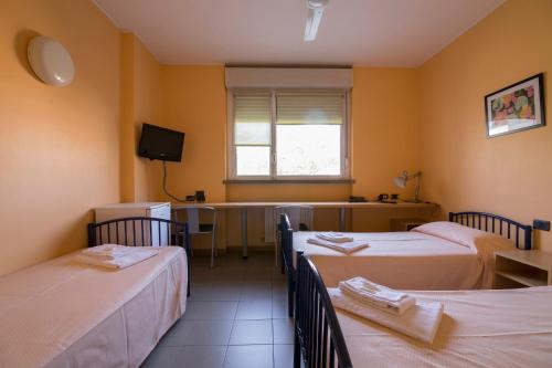a room with three beds and a desk in it at La Cordata Accommodation - Zumbini 6 in Milan