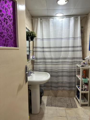 a bathroom with a sink and a shower at The Purple Place in Abu Dhabi