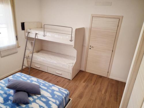 a small room with a bunk bed and a door at La Casera in Lido di Dante