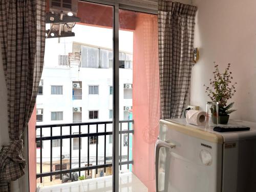 a kitchen with a window with a view of a building at Rest up @ Pattaya Hostel in Pattaya Central