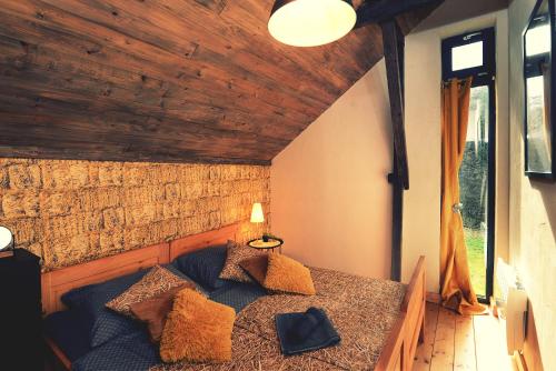 ein Schlafzimmer mit einem Bett in einem Zimmer mit Holzdecken in der Unterkunft OLHA Stara Gajówka in Weremień