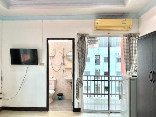 a living room with a television and a balcony at Rest up @ Pattaya Hostel in Pattaya Central