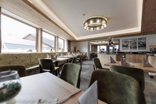a restaurant with tables and chairs and windows at Hotel Neuwirt in Mieming