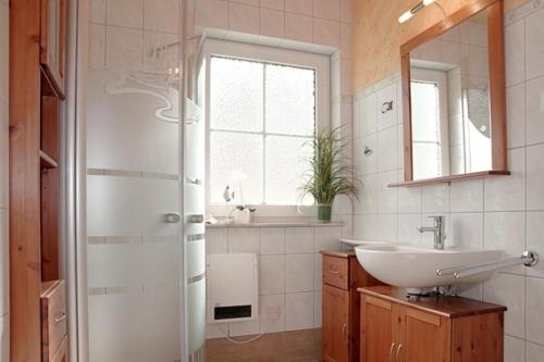 ein Bad mit einem Waschbecken und einem Spiegel in der Unterkunft Am Deich 24 in Zingst