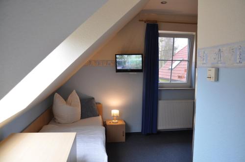 Kleines Zimmer mit einem Bett und einem Fenster in der Unterkunft Am Deich 24 in Zingst