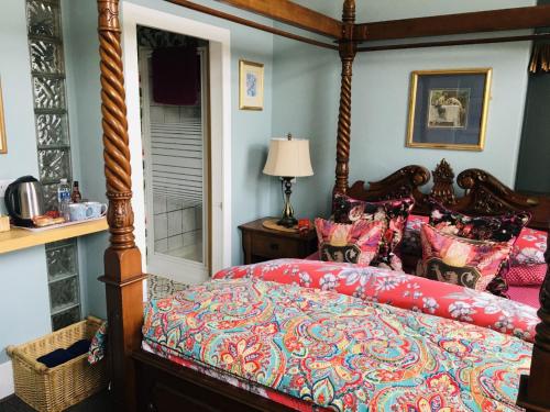 a bedroom with a large bed with a red comforter at The Forester and Flower in Bath