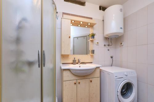 a bathroom with a sink and a washing machine at Apartment Dino 1 in Mali Lošinj