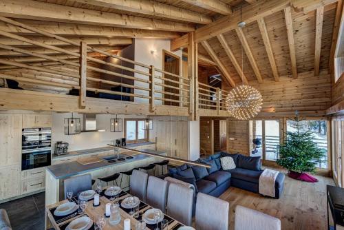 a kitchen and living room with wooden ceilings at Chalet la Chance in La Tzoumaz
