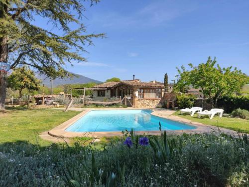 una piscina in un cortile con una casa di Casita con jacuzzi Rectoria de Dosquers a Maia de Montcal