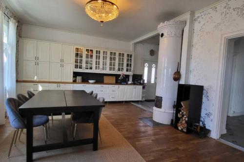 a kitchen with a table and chairs and a fireplace at Beautiful lake view house in Västerås