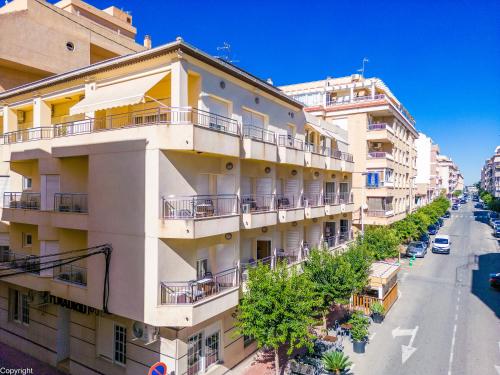 un edificio de apartamentos con balcones en una calle de la ciudad en Hotel Madrid, en Torrevieja
