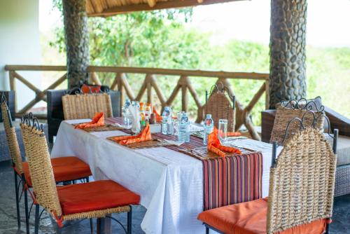 a table with orange decorations on a white table cloth at Buffalo Safari Lodge in Katunguru