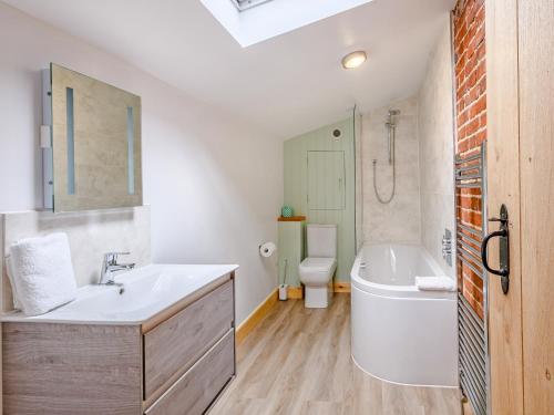 Freds Barn في Swanton Abbot: حمام مع حوض وحوض استحمام ومرحاض