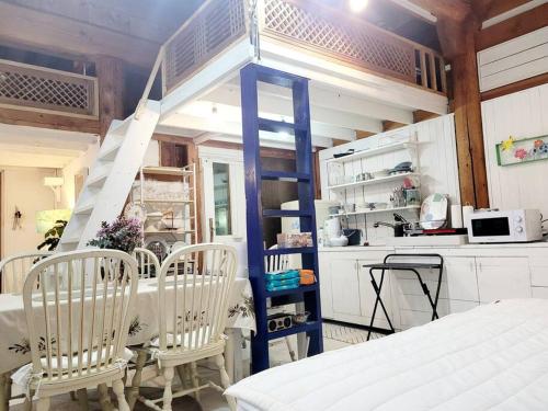 a kitchen with a table and chairs and a staircase at Hyanggyo-gil, Seonwooga in Jeonju