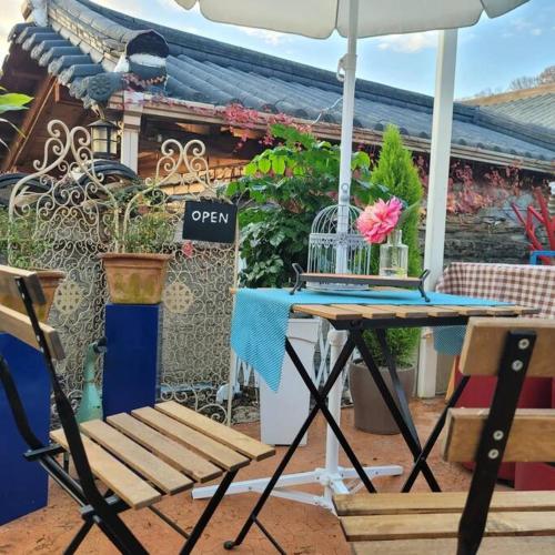 a table and chairs with an umbrella and a bird cage at Hyanggyo-gil, Seonwooga in Jeonju
