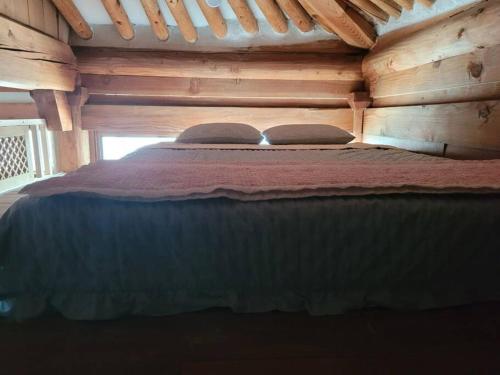 a bed in a log cabin with two pillows on it at Hyanggyo-gil, Seonwooga in Jeonju