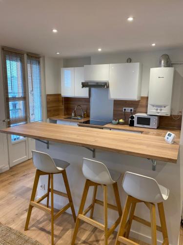 une cuisine avec un comptoir et deux tabourets dans l'établissement LE BOHEME CHIC PATTE D'OIE ****, à Toulouse