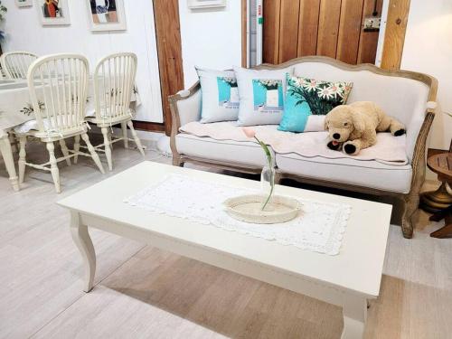 a dog laying on a couch with a coffee table at Hyanggyo-gil, Seonwooga in Jeonju
