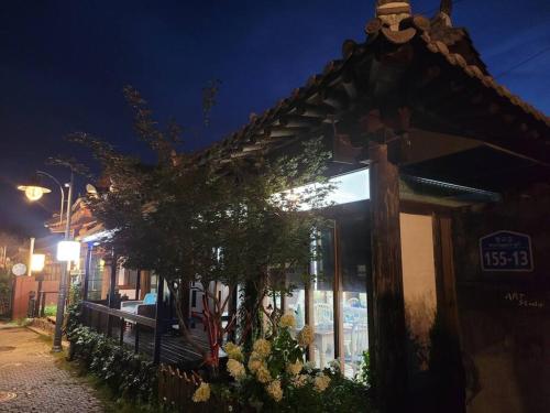 a building with a tree outside of it at night at Hyanggyo-gil, Seonwooga in Jeonju