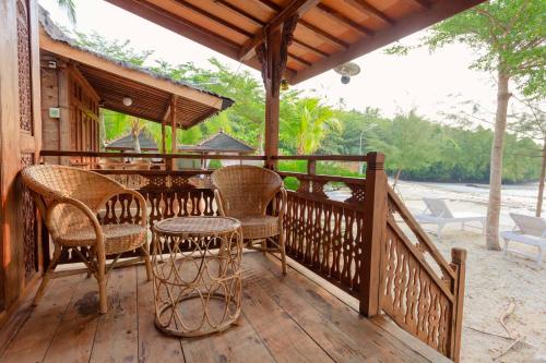a porch with chairs and a table on a deck at Bintan Exotica Resort By WH - Free Shuttle BBT Resort BBT - Free Breakfast in Berakit