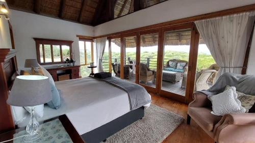 a bedroom with a bed and a couch and a chair at Oceans Voice in Jeffreys Bay